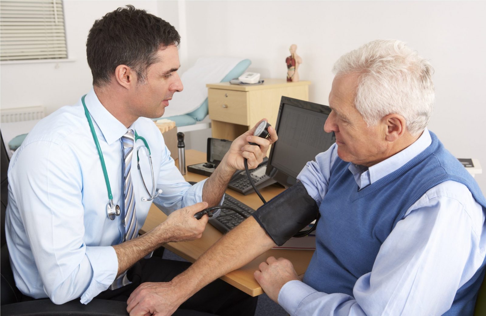 British doctor taking senior man's blood pressure